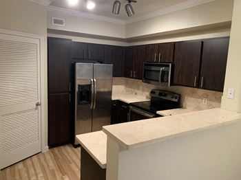 a kitchen with granite counter tops and a stainless steel refrigerator